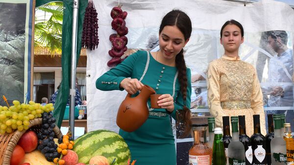 Девушка наливает вино на выставке в Сухуме