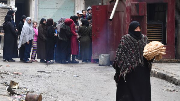 Местные жители в очереди за хлебом на одной из улиц в Алеппо