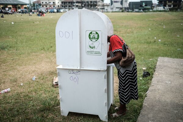 Женщина голосует на президентских и парламентских выборах на одном из избирательных участков в Порт-Харкорте, Нигерия