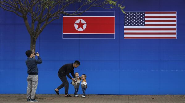 Люди фотографируются на фоне плаката к саммиту между США и Северной Кореей в Ханой, Вьетнам 