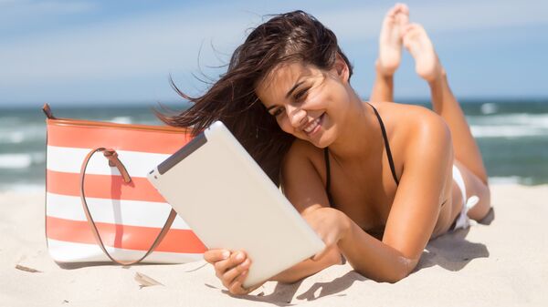 Девушка с планшетом на пляже