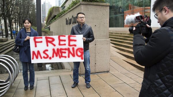 Люди с плакатом на улице Ванкувера в Канаде, выражающие поддержку финансовому директору компании Huawei Мэн Ваньчжоу, задержанной по требованию суда