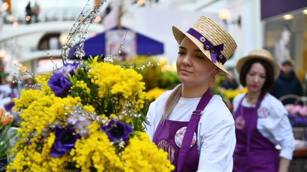 Продажа мимозы на Весеннем цветочном базаре в Петровском Пассаже в Москве