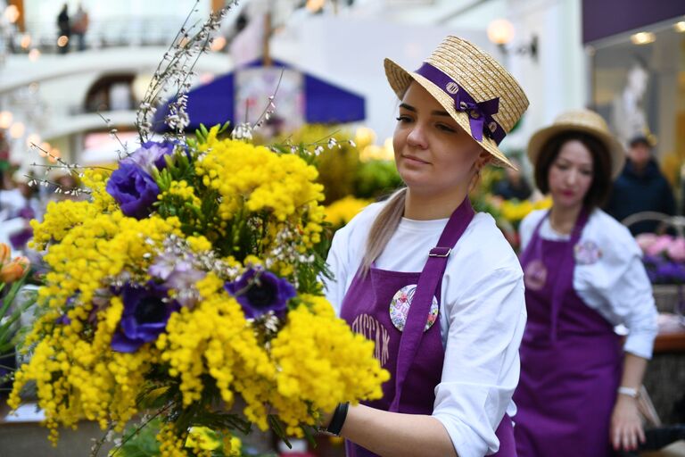 Продажа мимозы на Весеннем цветочном базаре в Петровском Пассаже в Москве