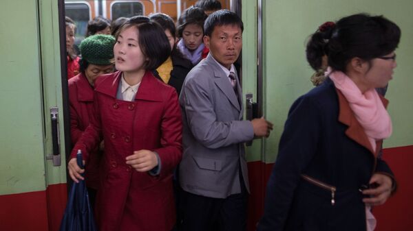 Пассажиры выходят из вагона поезда в метро в Пхеньяне