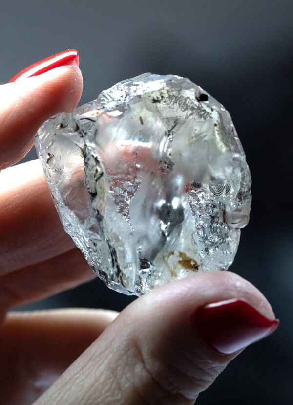 Сотрудница производит оценку алмаза в цехе технического контроля и оценки ООО Бриллианты Алроса в Москве