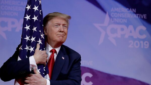 Президент США Дональд Трамп обнимает американский флаг