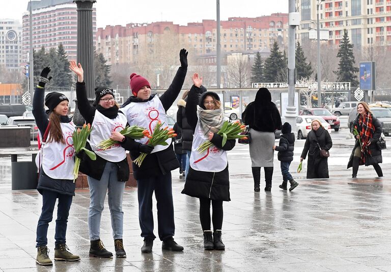 Волонтеры движения Мосволонтер, поздравляющие женщин с Международным женским днем в рамках добровольческой акции Вам, любимые!, у входа в Парк Горького в Москве