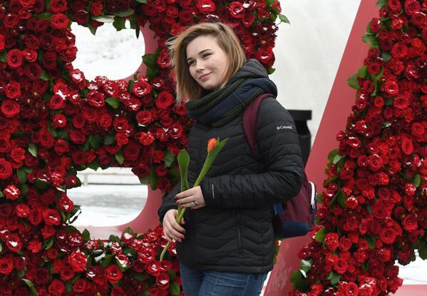 Девушка с тюльпаном, подаренным волонтерами движения Мосволонтер в рамках добровольческой акции Вам, любимые! , в парке Зарядье в Москве