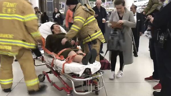 В аэропорту имени Джона Кеннеди медицинский персонал сопровождает пассажира, пострадавшего от турбулентности во время рейса Турецких авиалиний из Стамбула в Нью-Йорк. 9 марта 2019