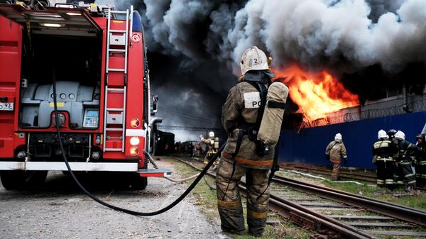 Сотрудники МЧС во время тушения пожара на складе с полиэтиленовой и бумажной тарой в промышленной зоне Краснодара. 12 марта 2019
