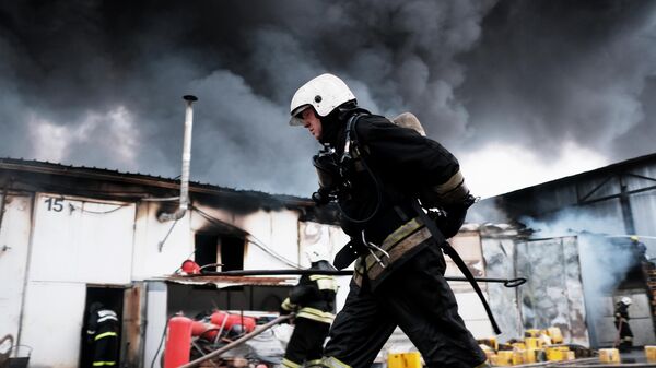 Сотрудники МЧС во время тушения пожара на складе с полиэтиленовой и бумажной тарой в промышленной зоне Краснодара. 12 марта 2019 