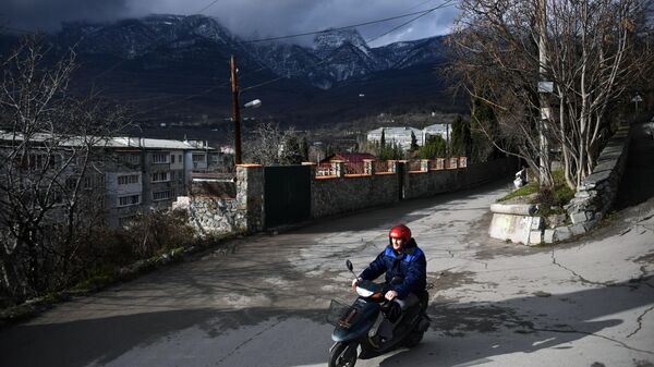 Мужчина едет на мопеде в Гурзуфе в Крыму