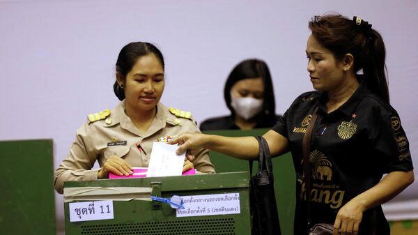 Женщина во время голосования на избирательном участке в Бангкоке
