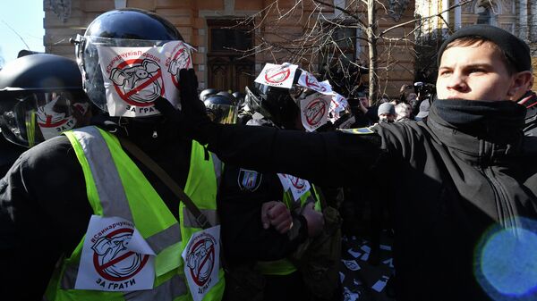 Активисты Национального корпуса клеят стикеры с изображением свиньи на сотрудников полиции во время акции протеста в Киеве, Украина