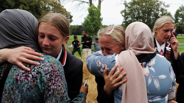 Старшеклассники христианской школы обнимают мусульманок, ждущих новостей о своих родственниках, пострадавших при стрельбе в мечете, Крайчестер, новая Зеландия. 18 марта 2019