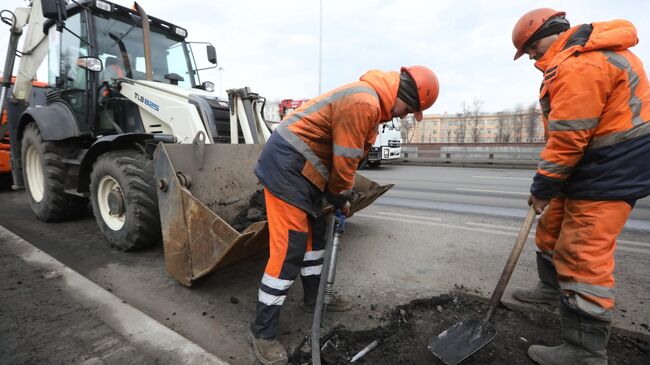 Рабочий бригады ГБУ Автомобильные дороги демонтирует старое дорожное полотно пневматическим отбойным молотком в Москве