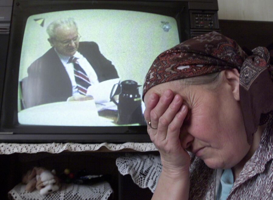 Боснийская женщина плачет, наблюдая по телевизору за трибуналом над Слободаном Милошевичем. 14 февраля 2002