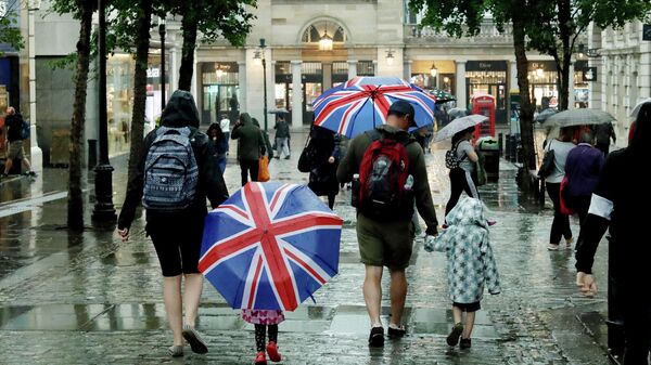 Дети с зонтами в цвет флага Великобритании на Ковент-гарден в Лондоне 
