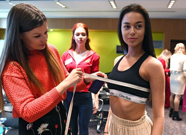 Замерщица снимает мерки с участницы конкурса Мисс Россия в Москве