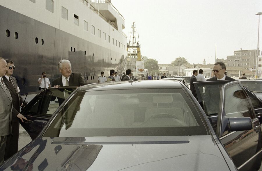 Президент России Борис Ельцин и министр иностранных дел Андрей Козырев садятся в машину в порту Греции. 11 июня 1994