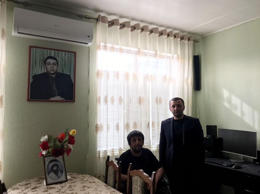 Магомед Гамзатов вместе со старшим братом на фоне портрета отца, убитого боевиками