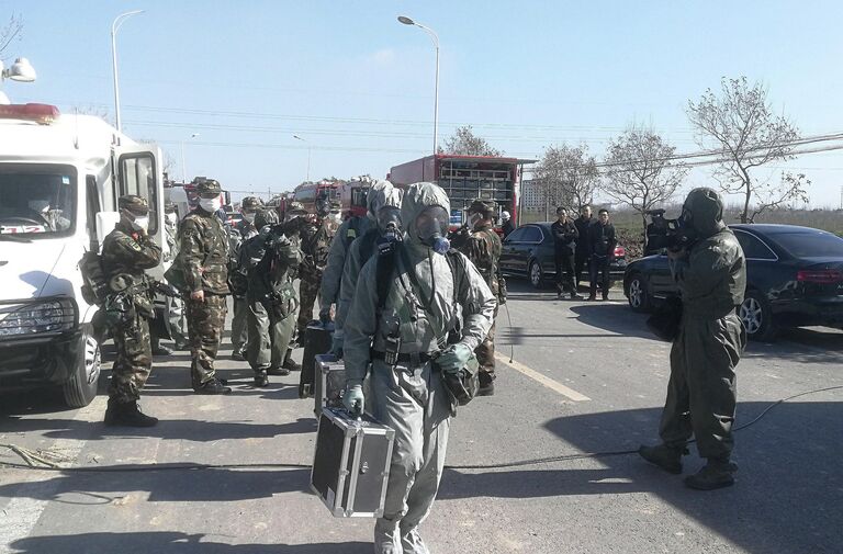 Сотрудники военизированной полиции в защитных костюмах пробираются к месту взрыва на заводе пестицидов Цзянсу Тяньцзяи в провинции Цзянсу, Китай. 22 марта 2019