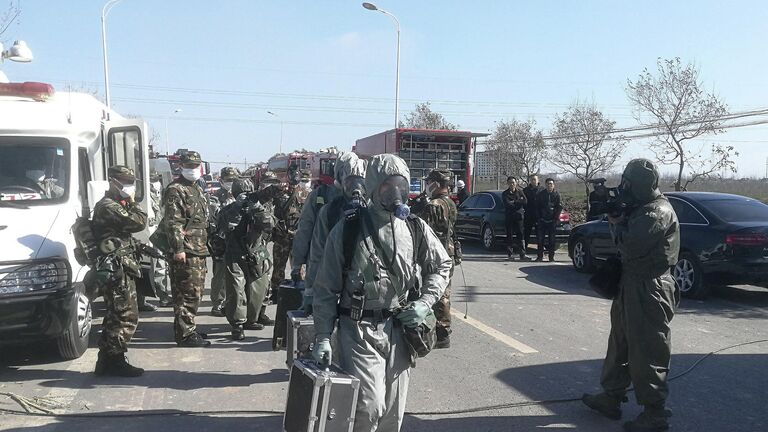 Сотрудники военизированной полиции в защитных костюмах пробираются к месту взрыва на заводе пестицидов Цзянсу Тяньцзяи в провинции Цзянсу, Китай. 22 марта 2019