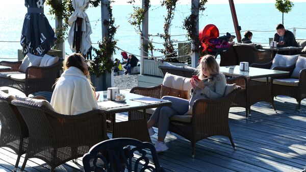 Отдыхающие в кафе на берегу Черного моря в Сочи