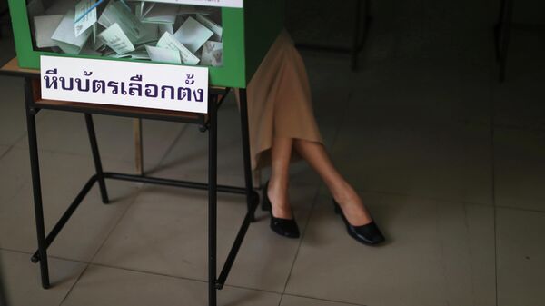  Служащий у избирательной урны на участке парламентских выборов в Таиланде. 24 марта 2019