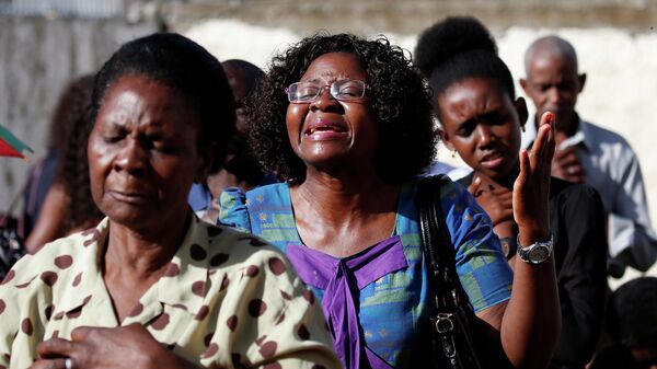 Прихожане молятся на улице после того, как их церковь была разрушена циклоном Идаи в Бейре, Мозамбик. 24 марта 2019