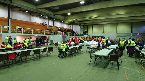 Волонтеры и спасатели, участвующие в эвакуации людей с круизного лайнера Viking Sky, собираются в местном спортивном зале. Хустад, Норвегия 
