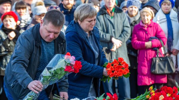 Люди возлагают цветы к мемориалу в память о жертвах пожара в торгово-развлекательном центре Зимняя вишня в Кемерово