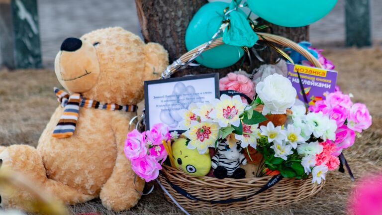 Цветы и мягкие игрушки у мемориала в память о жертвах пожара в торгово-развлекательном центре Зимняя вишня в Кемерово