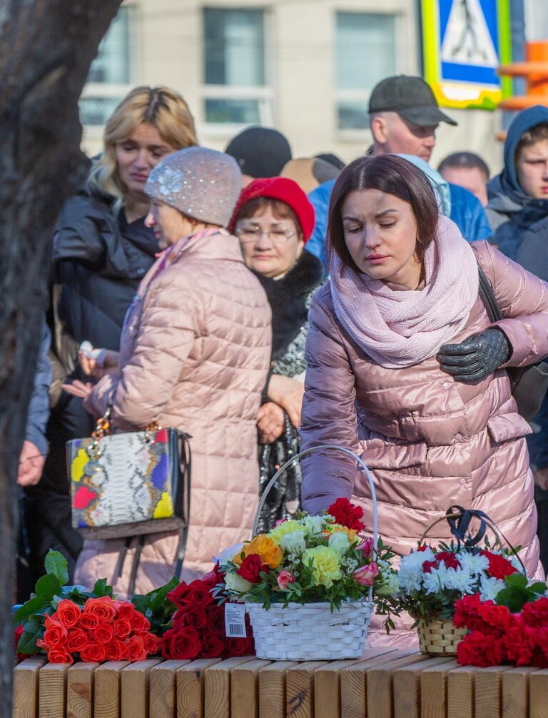 Девушка возлагает цветы к мемориалу в память о жертвах пожара в торгово-развлекательном центре Зимняя вишня в Кемерово