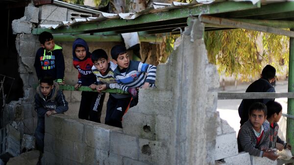Палестинские мальчики в здании, разрушенном в результате ударов Израиля 