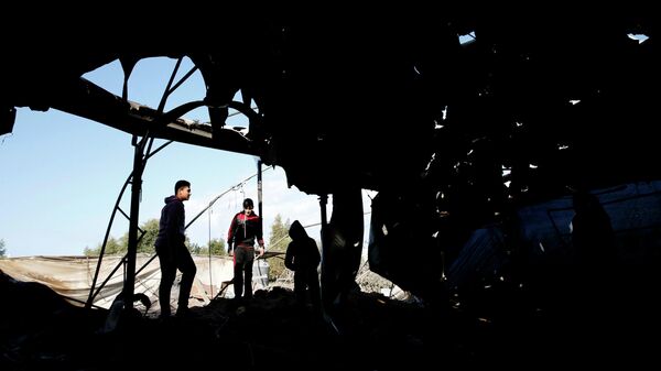 Палестинцы осматривают мечеть, которая была повреждена в результате израильского авиаудара в Газе