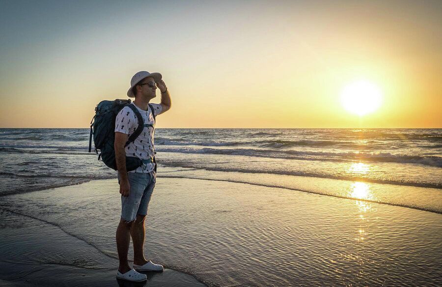Александр Беленький на пляже с рюкзаком