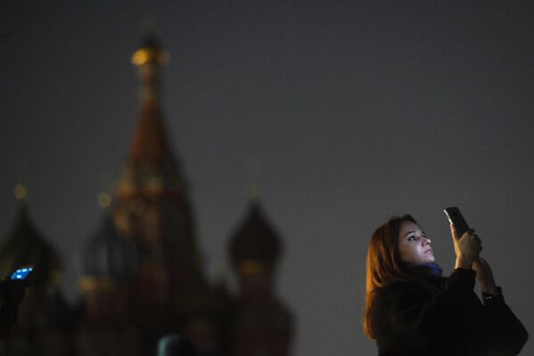 Девушка на Красной площади в Москве во время отключения подсветки в рамках экологической акции Час Земли