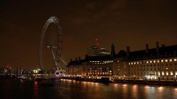 Колесо обозрения Лондонский глаз на набережной Темзы после отключения подсветки в рамках экологической акции Час Земли
