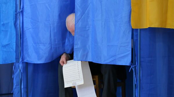 Мужчина изучает бюллетень на выборах президента Украины на одном из избирательных участков