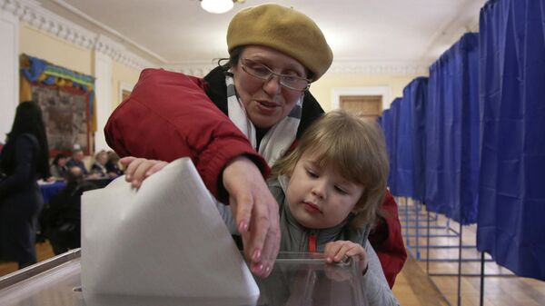 Женщина голосует на избирательном участке во время президентских выборов в Киеве, Украине