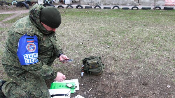 Офицер СЦКК фиксирует попадание снаряда в поселке Гольмовский города Горловка. 2 апреля 2019
