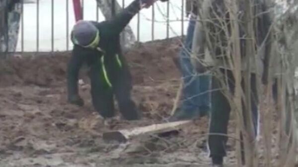 Мальчик, застрявший в грязи по дороги в школу в Малоярославце