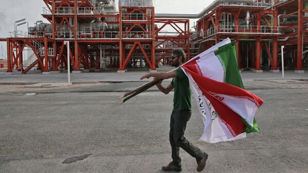 Мужчина с флагами Ирана на заводе по переработке природного газа