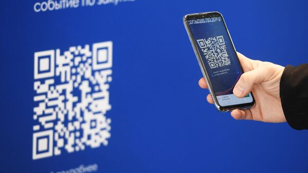 Посетитель сканирует QR-код на стенде XV юбилейного Всероссийского форума-выставки Госзаказ