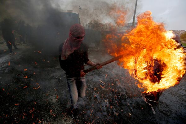 Палестинец во время столкновений с израильскими войсками после демонстрации, посвященной Дню земли