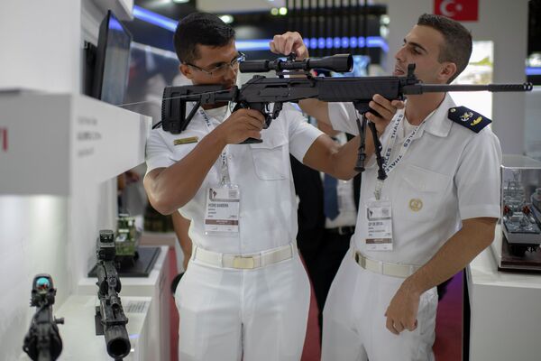 Военнослужащие ВМФ Бразилии осматривают прицел огнестрельного оружия на выставке LAAD Defense & Security 2019 в Рио-де-Жанейро