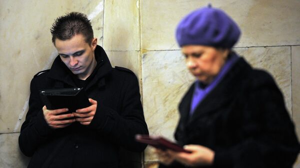 Пассажиры с портативными устройствами на одной из станций Кольцевой линии московского метрополитена