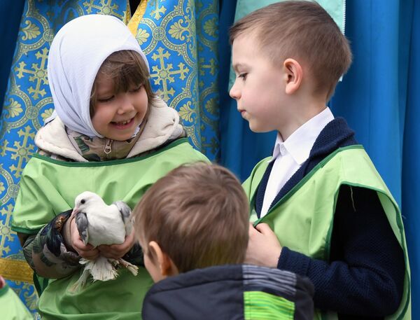 Дети готовятся выпустить голубей в небо над Соборной плщадью после богослужения в праздник Благовещения Пресвятой Богородицы в Благовещенском соборе Московского Кремля